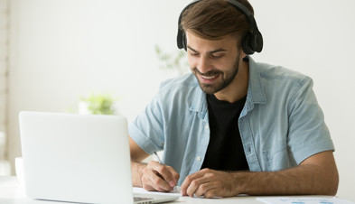 Young man in headphones working at a laptop